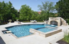 an outdoor swimming pool surrounded by landscaping