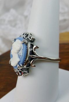 "Cameo Ring Description Vampire Design#84 Made to Order Inspired by Gothic & Renaissance era jewelry, I now offer this lovely Antique styles ring in sterling silver. This gorgeous ring is set with a flawless simulated/man-made blue aquamarine gemstone. This flawless aqua gem has excellent color and clarity. The full cut 5ct oval aquamarine is 14mm (9/16th of an inch) Long by 10mm Wide (3/8th\"). The ring sits 7mm off the finger. The inside of the band is marked 925 for sterling. Notice the i Ornate Cameo Jewelry For Anniversary, Handmade Victorian Style Rings, Ornate Round Cameo Jewelry, Elegant Cameo Rings For Collectors, Victorian Oval Cabochon Wedding Jewelry, Blue Cameo Jewelry For Wedding, Elegant Nickel-free Wedding Rings, Elegant Nickel Free Wedding Rings, Oval Cameo Sterling Silver Jewelry