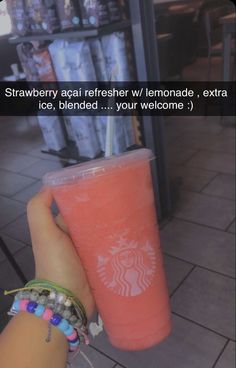 someone holding up a pink starbucks drink in front of a store with the caption strawberries get fresher / lemonade, extra flakes, blended, and your welcome