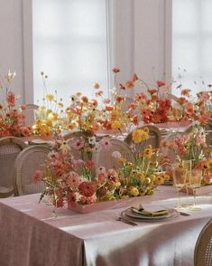 the table is set with flowers and place settings