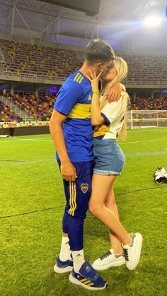 a man and woman standing next to each other on a soccer field