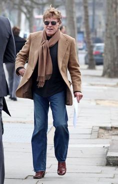 a man walking down the street with a scarf around his neck