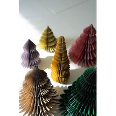 several folded paper christmas trees on a white surface