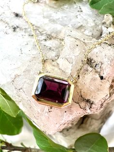 This timeless rhodolite garnet necklace is crafted with expert care and attention to detail. The bezel-set gemstone is set into 14kt yellow gold for a stunning, classic look that will be admired for years to come. This necklace features:-1.50 carat Rhodolite Garnet-Bezel Setting-14KT Yellow Gold -16-18in adjustable chainStyle #235-00109 Earrings Not Included Elegant Yellow Gold Tourmaline Necklace, Elegant Tourmaline Yellow Gold Necklace, Formal Yellow Gold Tourmaline Necklaces, Formal Yellow Gold Tourmaline Necklace, Formal Ruby Necklace With Bezel Setting, Formal Yellow Gold Garnet Necklaces, 14k Gold Octagon Gemstone Necklace, Formal Yellow Gold Garnet Necklace, Classic Garnet Gemstone Necklace