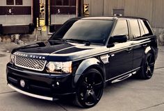 a black range rover parked in front of a building