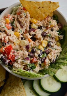 a white bowl filled with chicken salad and tortilla chips