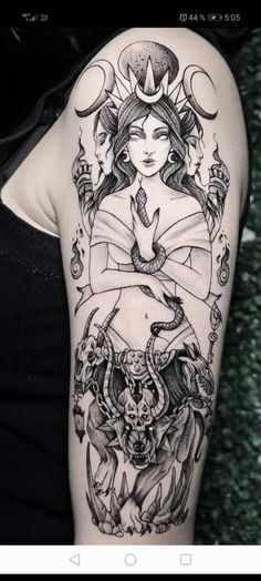 the back of a woman's arm with tattoos on it and an image of a demon