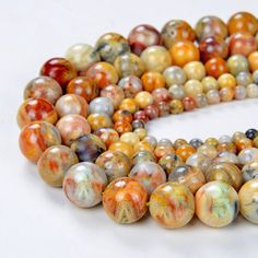 multicolored marble beads are arranged on a white surface