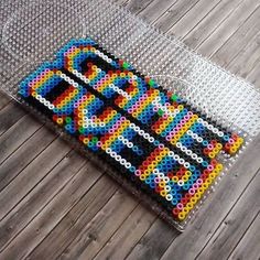 a piece of art made out of legos sitting on top of a wooden floor