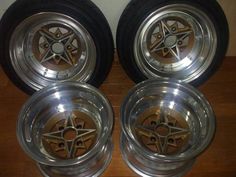 four rims and tires are sitting on the floor