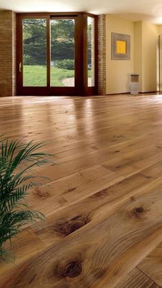 an empty room with wooden floors and large windows