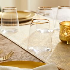 the table is set with gold plates and glasses