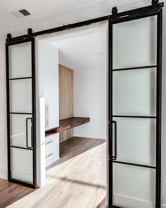 an open door leading into a room with wooden floors and white walls in the background