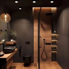 a modern bathroom with wooden floors and black fixtures on the walls, along with a walk in shower