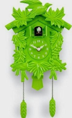 a green cuckoo clock with leaves on the front and sides, hanging from a chain