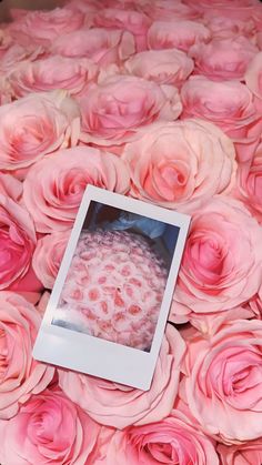 a bouquet of pink roses with a photo frame on it's center surrounded by smaller flowers