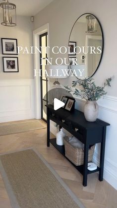 a hallway with a black table and mirror