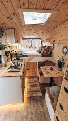 an interior view of a small camper with wood paneling and white bedding