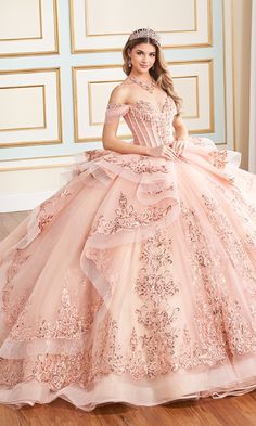 Glitter tulle quinceanera dress with an off-the-shoulder neckline, lace applique, stone accents, and covered buttons down the front of the corset bodice. This quinceanera ball gown features draped off-the-shoulder straps and a semi-sheer bodice. Baby Pink Quinceanera Dresses With Gold, Pink Princess Quinceanera Dress With Fitted Bodice, Pink Quinceanera Dress With Lace Bodice, Sparkly Rose Gold Off The Shoulder Quincenera Dress, Pink Embellished Quinceanera Gown, Rose Gold Quince, Ariel Wedding, Quinceanera Dresses Pink, Dazzling Dress