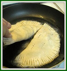 two pita breads being cooked in a skillet