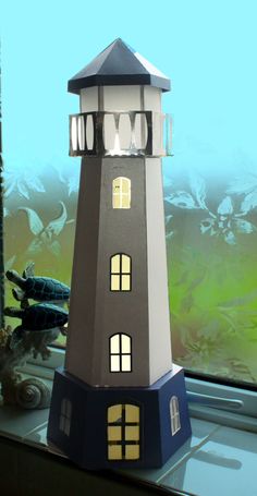 a paper model of a lighthouse on a window sill