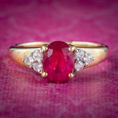 A fabulous Art Deco inspired ring claw set with a gorgeous, cherry-pink synthetic ruby in the centre (approx. 1.5ct) flanked by triangular shoulders set with three twinkling white sapphires (approx. 0.30ct total).  Ruby has been a favourite of kings and emperors throughout history and is considered a stone of the heart. Its fiery pink/ red hue is symbolic of passion and said to bring good fortune in love and provide long lasting happiness and vitality to any relationship. The sleek band is all 9 Ruby Wedding Anniversary Gifts, Antique Ruby Ring, Ruby Wedding Anniversary, Ruby Wedding, Pink Sapphire Ring, Pink Topaz, Ruby Sapphire, Antique Pink, Wedding Anniversary Gift