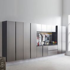 an empty kitchen with stainless steel appliances and white walls, in front of a large window