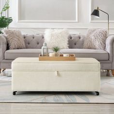 a living room with a couch, ottoman and coffee table