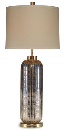 a table lamp with a white shade on it and a gold metal base is shown