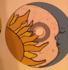 a disc with the image of a sun and a woman's face painted on it