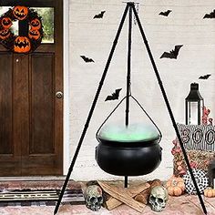 an outdoor halloween decoration with bats, skulls and a caulder