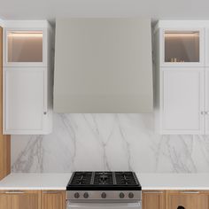 a stove top oven sitting inside of a kitchen next to white cabinets and cupboards