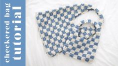 a blue and white tie sitting on top of a bed next to a book cover