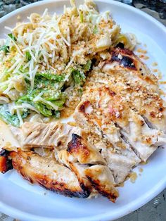 a white plate topped with chicken, pasta and broccoli covered in grated cheese