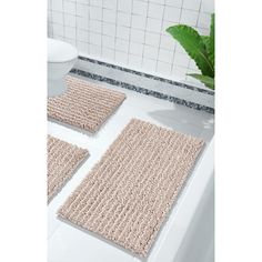 three bath mats on the floor in a bathroom