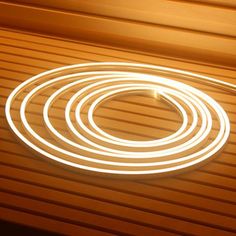 a close up of a light on a wooden floor with a circular object in the middle