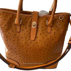 Caramel Dooney & Bourke Ostrich Handbag Can Be Worn On The Shoulder, Crossbody And By The Handles. Two Inside Zip Pocket And 3 Inside Pockets. Handle Drop Length 4". Adjustable, Detachable Strap That Can Also Be Worn As A Cross Body. The Straps Can Be Adjusted To A Length Of 25" With Metal Feet. Zipper And Turn Lock Closure. This Bag Is In Excellent Condition And Carried A Couple Of Times. Dooney Bourke Ostrich Handbags, Ostrich Handbags, Brown Bag With Double Handle And Gold-tone Hardware, Everyday Handbag Dooney & Bourke, Dooney & Bourke Bags Vintage, Hobo Purses Dooney & Bourke, Dooney & Bourke Bags, A Cross, Dooney Bourke