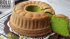 a bundt cake with green frosting on a plate next to a piece of cake