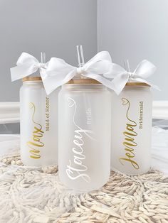 three white and gold wedding canisters with bows on them sitting on a table