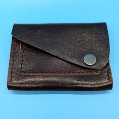 This stylish handmade brown leather wallet is the perfect accessory for anyone. The wallet features a sleek design with a sturdy antique nickel snap closure, keeping your belongings secure while adding a touch of sophistication to your look.  With a single card slot on the front and a spacious main compartment, this wallet is both practical and fashionable, making it ideal for everyday use. Upgrade your accessory game with this timeless piece that will never go out of style. Length:  4.75" Width Brown Wallets With Snap Closure For Everyday Use, Brown Wallet With Snap Closure For Everyday Use, Brown Leather Wallet With Snap Closure, Handmade Brown Wallet For Everyday Carry, Brown Bifold Coin Purse With Snap Closure, Brown Wallet With Belt Clip For Everyday Carry, Classic Brown Trifold Wallet For Everyday Use, Classic Brown Bifold Coin Purse, Vintage Brown Trifold Wallet For Everyday Carry