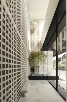 a long hallway with white walls and black trimmings on the wall, leading to an outdoor area