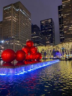 a large red sculpture in the middle of a city at night with lights on it