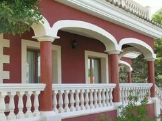 a red and white house with columns on the front porch