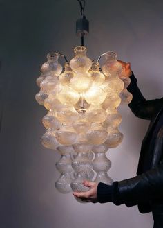 a chandelier made out of blown glass balls hanging from a ceiling light fixture