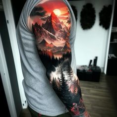 a man's arm with mountains and trees on it