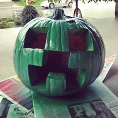 a green pumpkin sitting on top of a newspaper