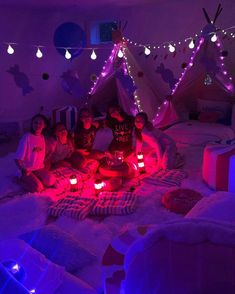 a group of people sitting on top of a bed in a room filled with lights