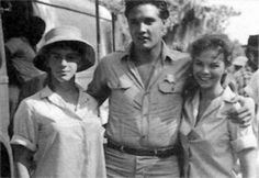 an old black and white photo of three people standing next to each other in front of a bus