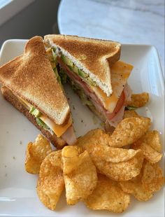 a sandwich and chips on a white plate