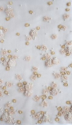 white and gold sequins on fabric with flowers in the center, closeup